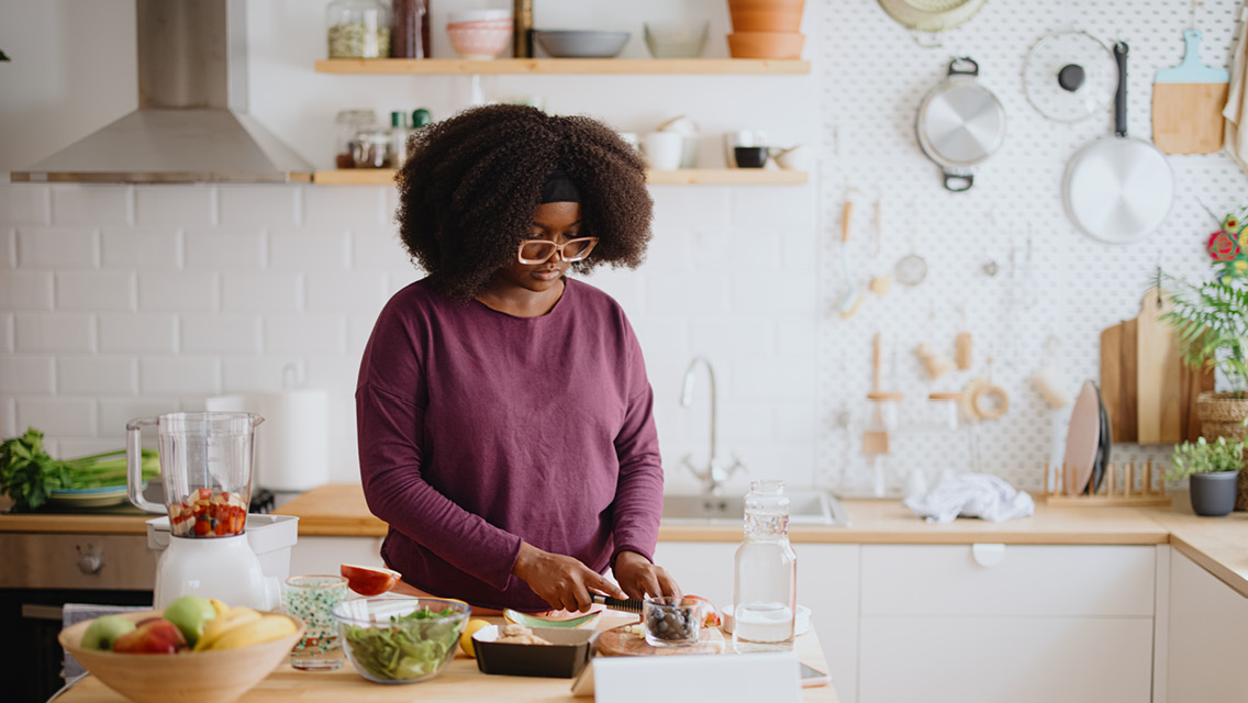 a woman prepares whole foods in her kitchen