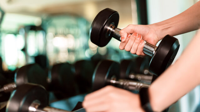 Person picking up dumbbell at the gym