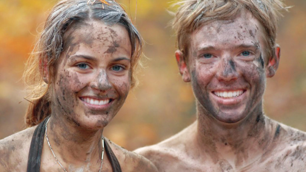 two muddy young adults