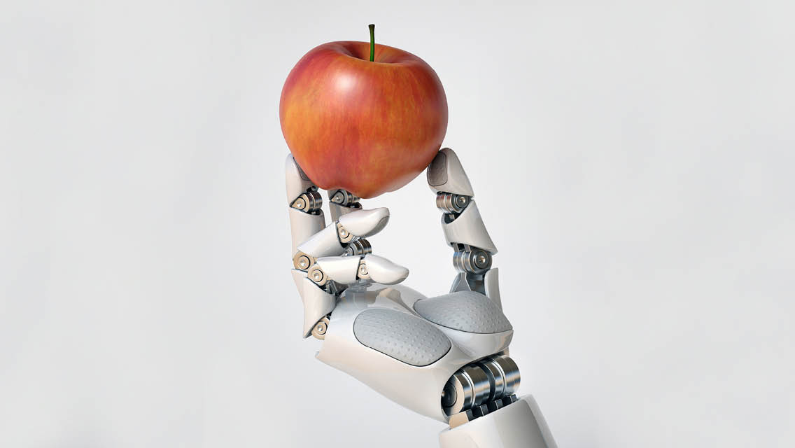 a robot's hand holding an apple