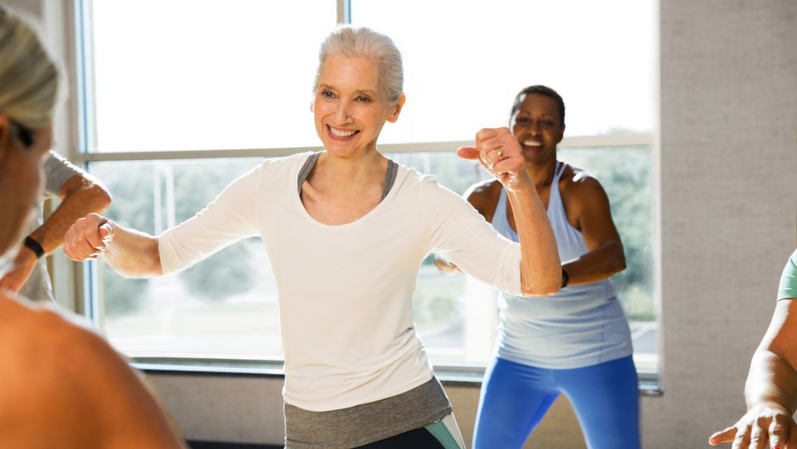 A group of active, older adult women in a dance class.