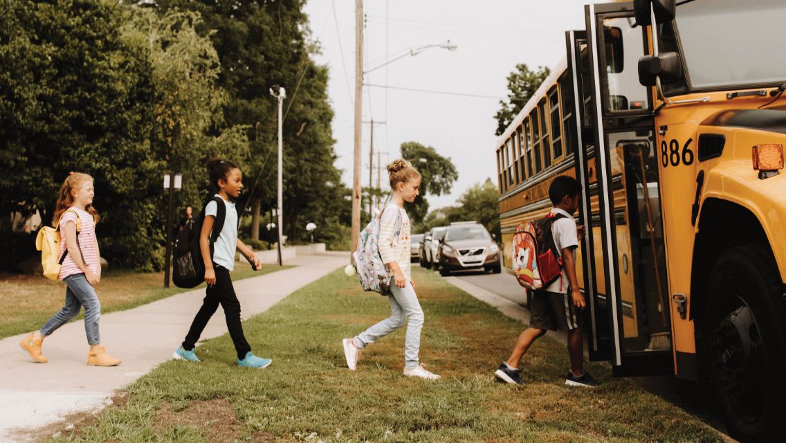 Kids walking onto a school bus