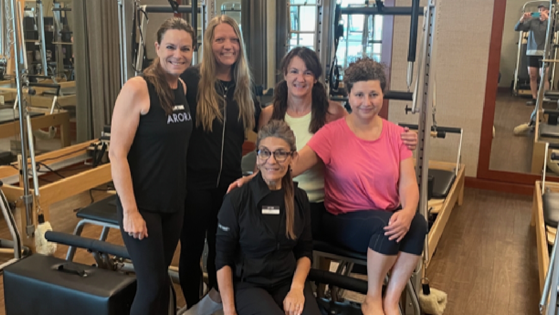 Renee Main and her Pilates instructor, Mitra, along with the three other women who take her class together.
