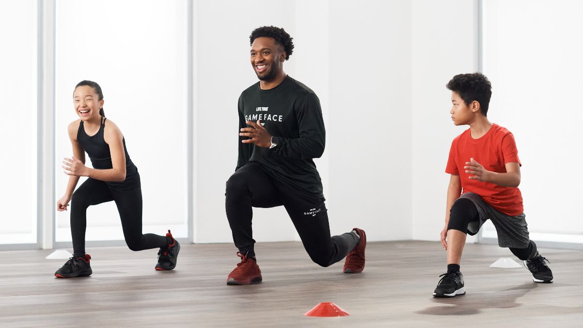 A GameFace trainer doing the workout with two younger kids.
