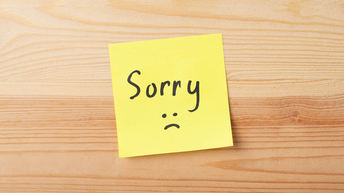 a post it note with sorry written on it