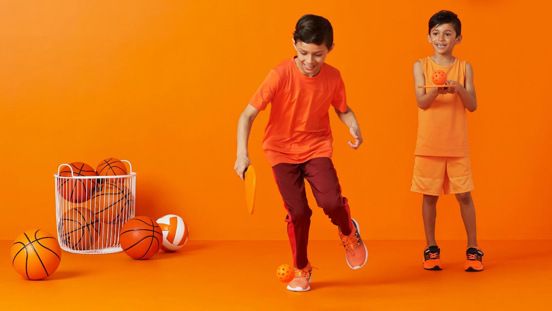 Two young boys playing with sports equipment.