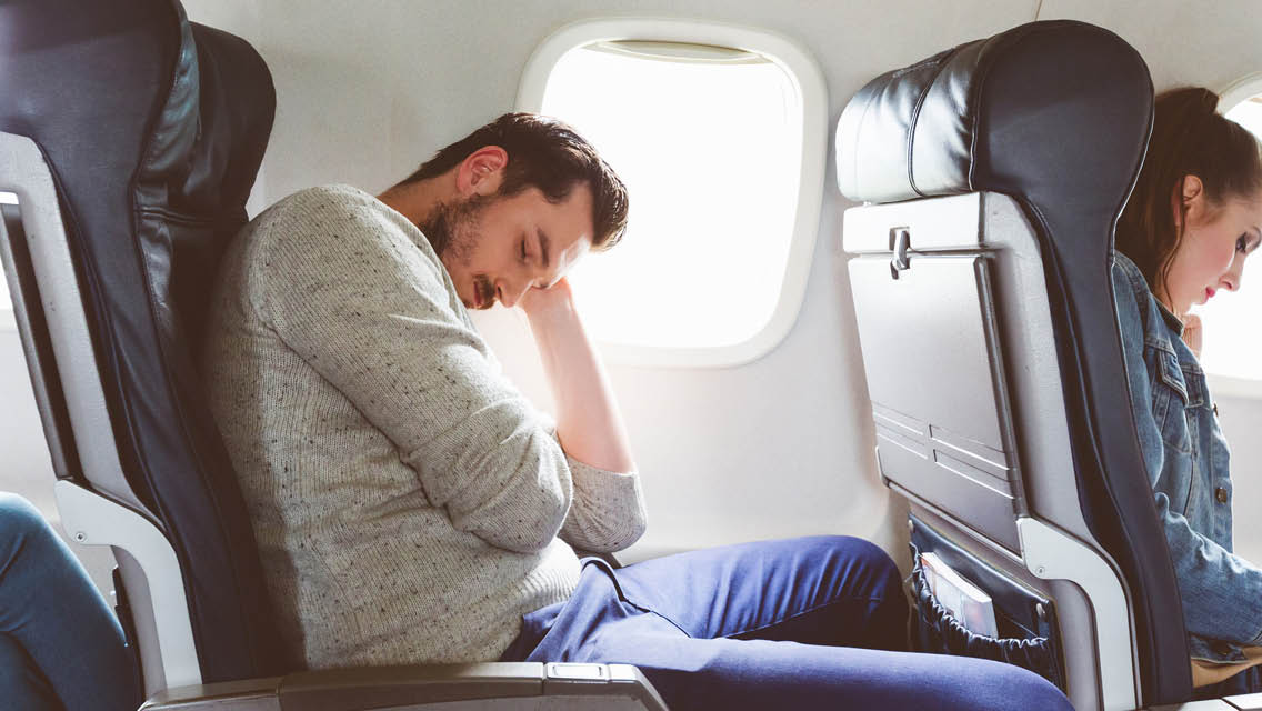 a man sleeps on a plane