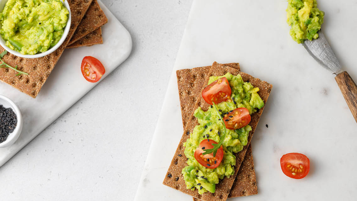 rye crackers with sliced cherry tomatoes and avocado