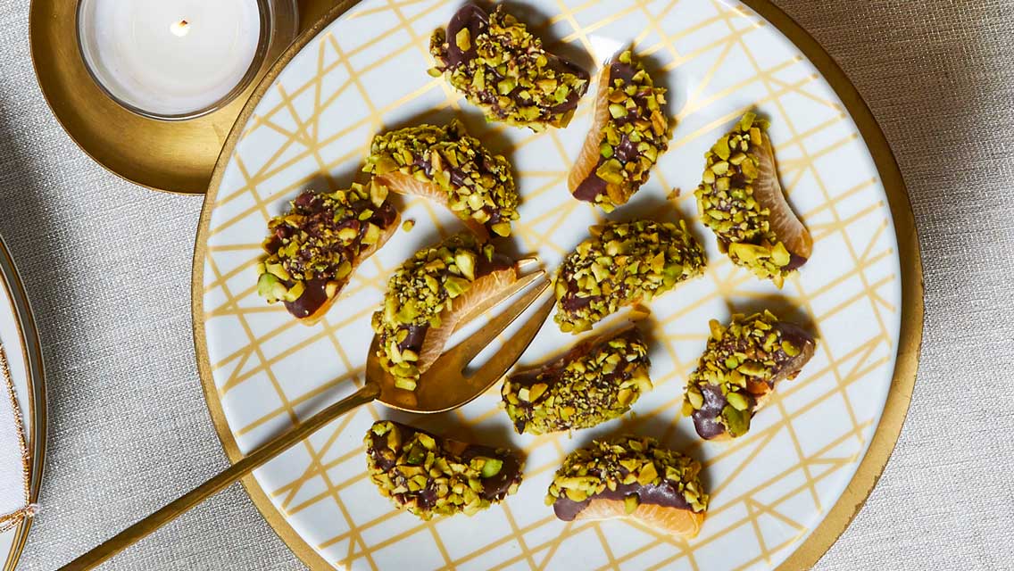 chocolate dipped mandarines coasted with crushed pistachios