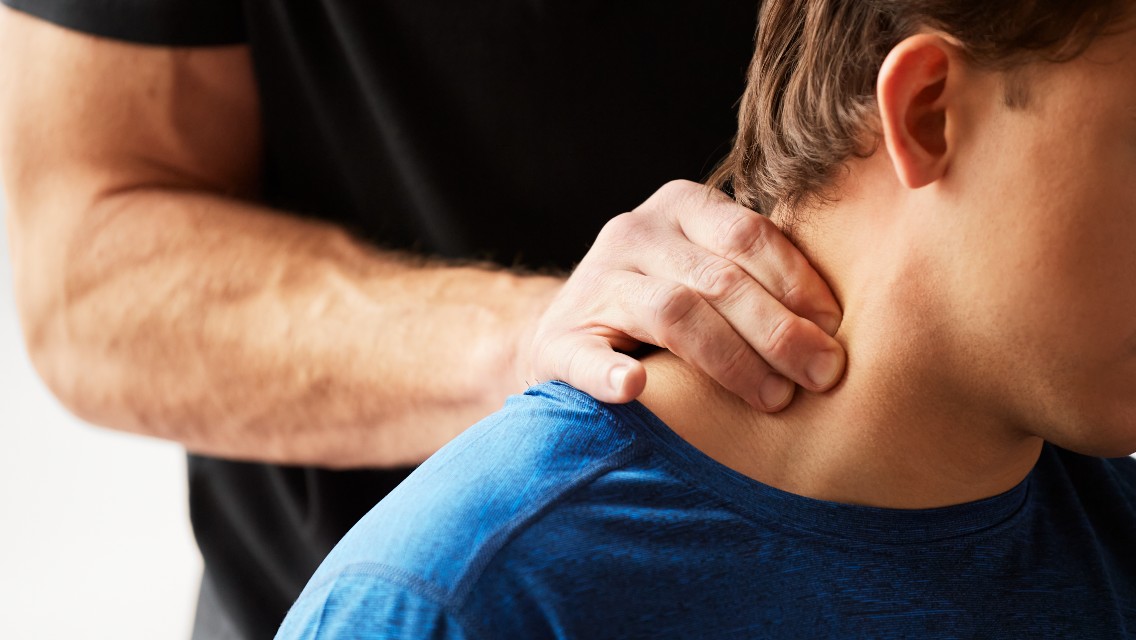 A man adjusting another man's neck.