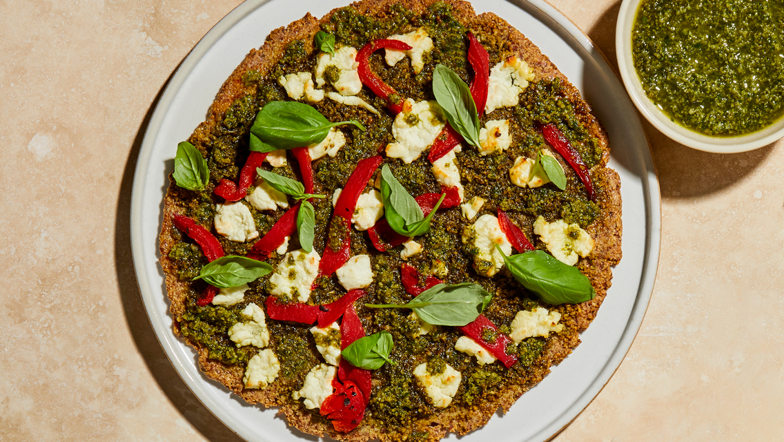 almond crust pizza with fresh pesto, peppers, and basil