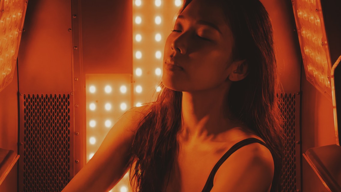 Person sitting in a red-light therapy sauna