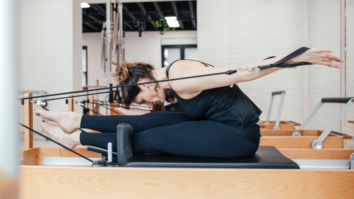 Person doing Pilates on a reformer
