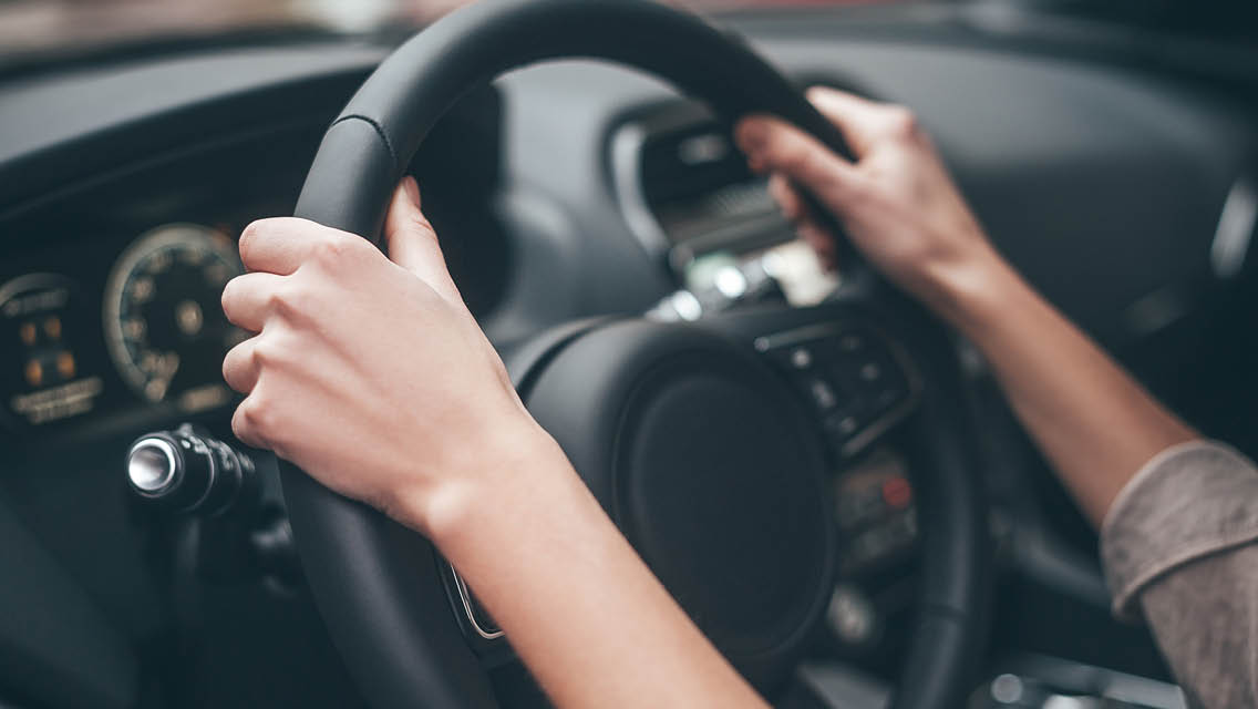 hands grip a steering wheel
