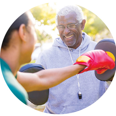 a senior man works with his partner during a boxing workout