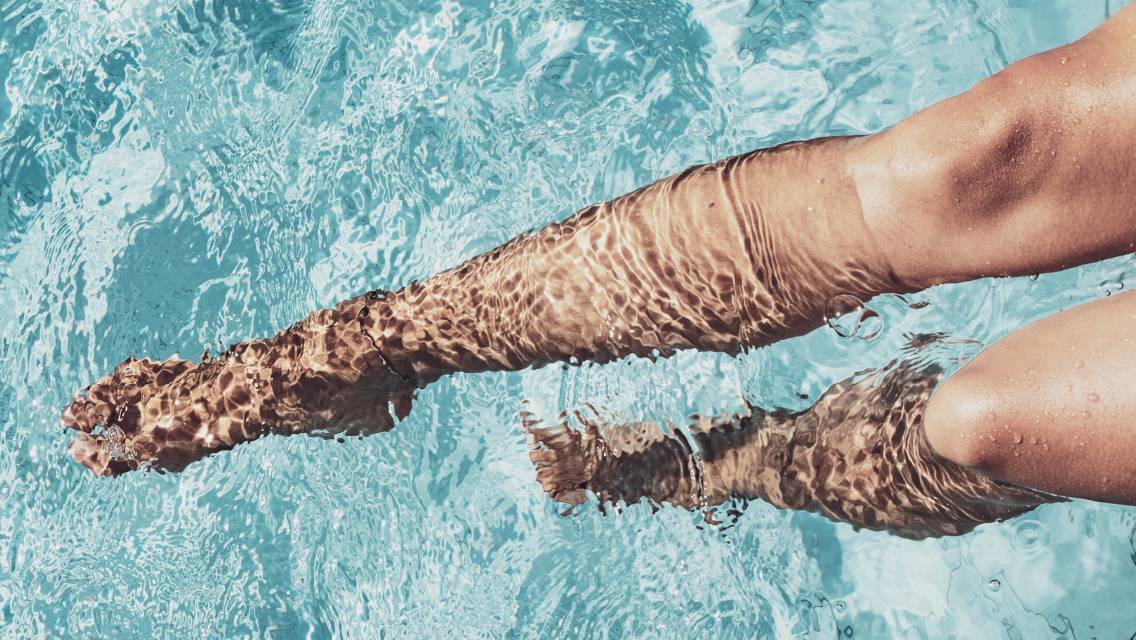 A person's legs in pool water