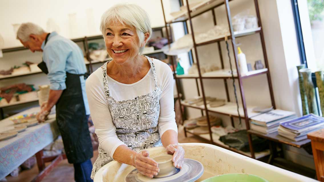 a woman works on pottery