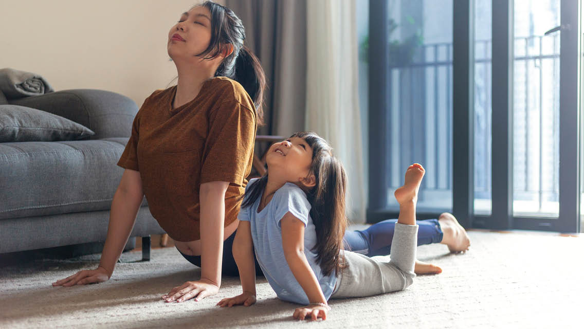 a mom and daughter do yoga together
