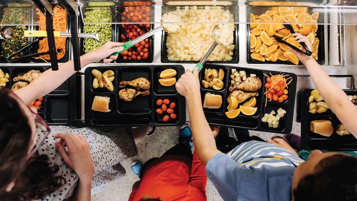 kids dishing healthy foods onto school lunch trays