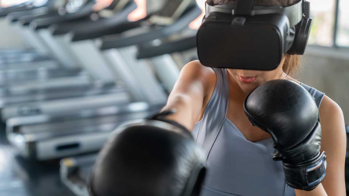 a woman uses virtual reality goggles to box