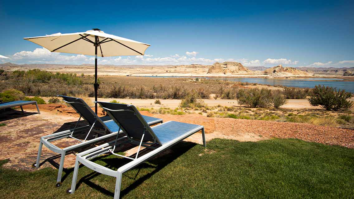 two lounge chairs sit overlooking a desert landscape
