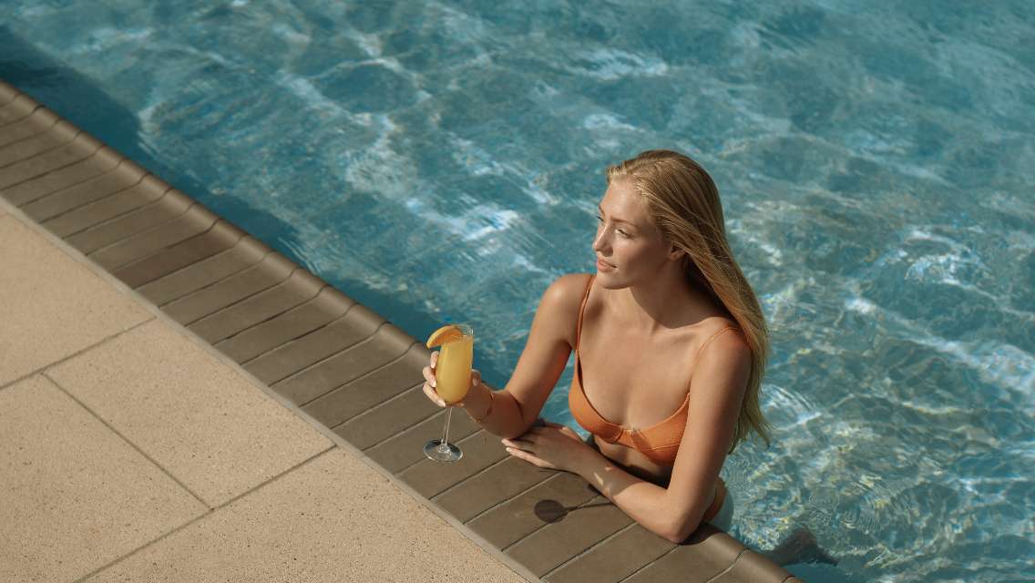 Person in the pool with a drink