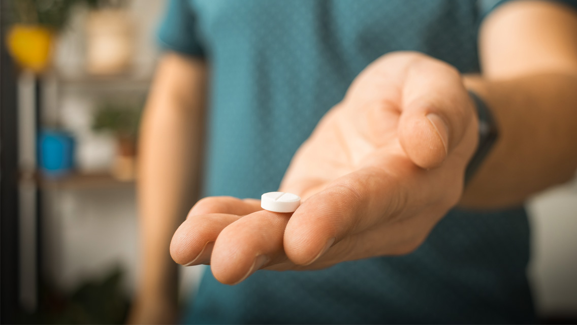 a man holds a pill