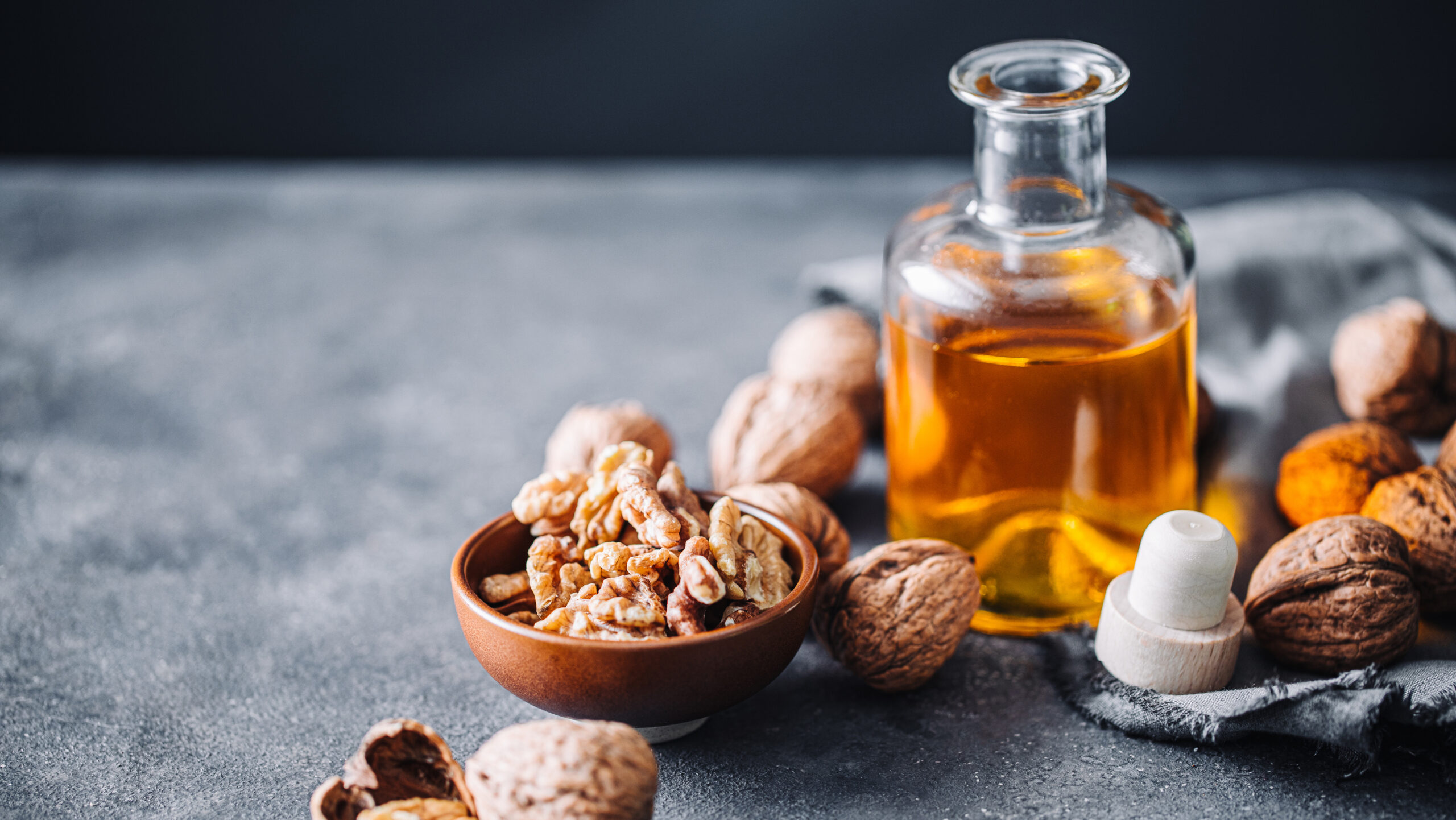 Bowl of walnuts and flax seed oil in glass bottle s