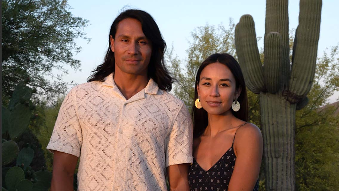 Two people are pictured with a cactus tree in the background.