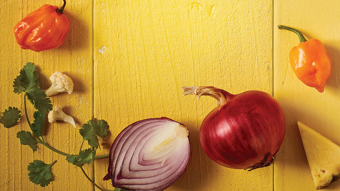 a variety of vegetables that make up traditional Mexican food on a yellow wood background