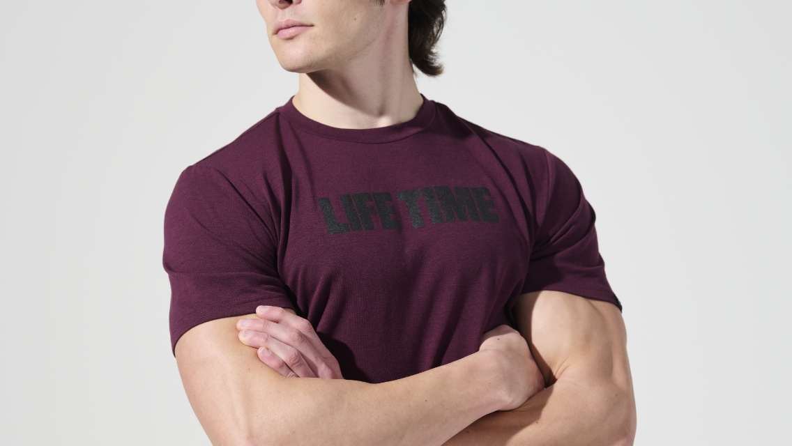 man wearing maroon life time tee shirt