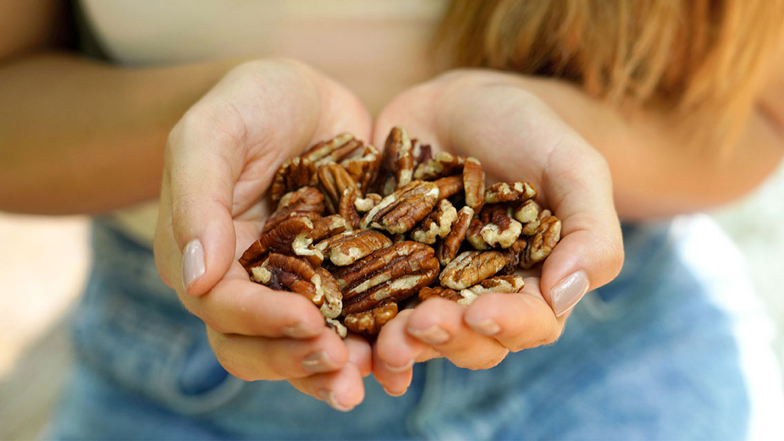 a person holds a handful of nuts