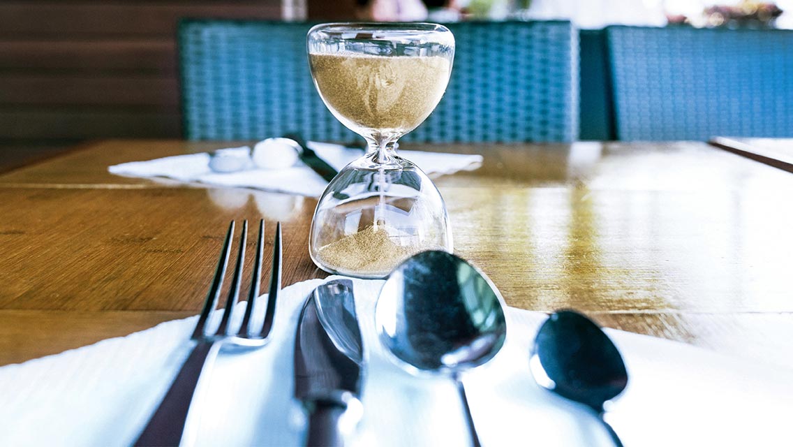 a table with a sand timer and utensils