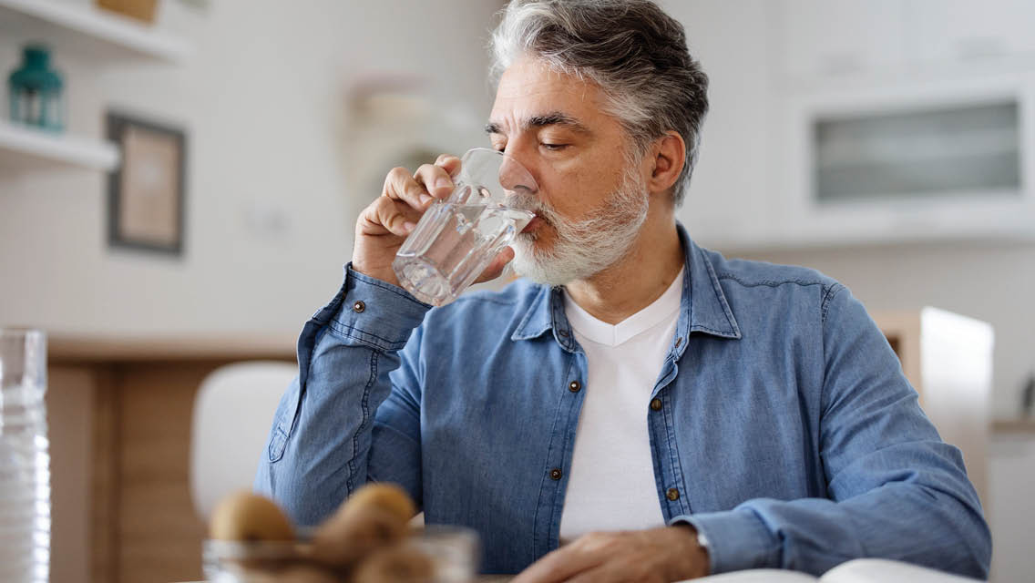 a man drinks a glass of water