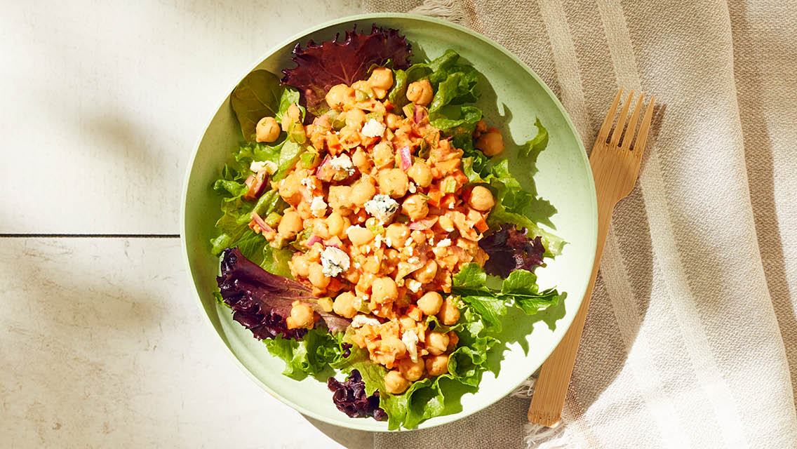 buffalo chickpea salad served on a bed of greens