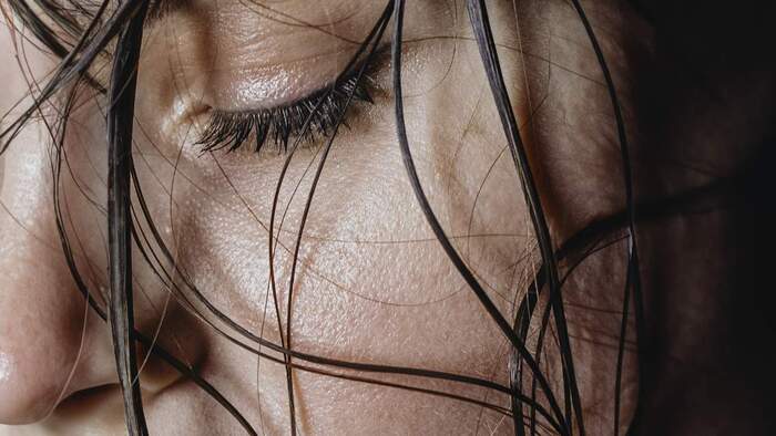 Close-up of a person's face with damp hair falling in front of it