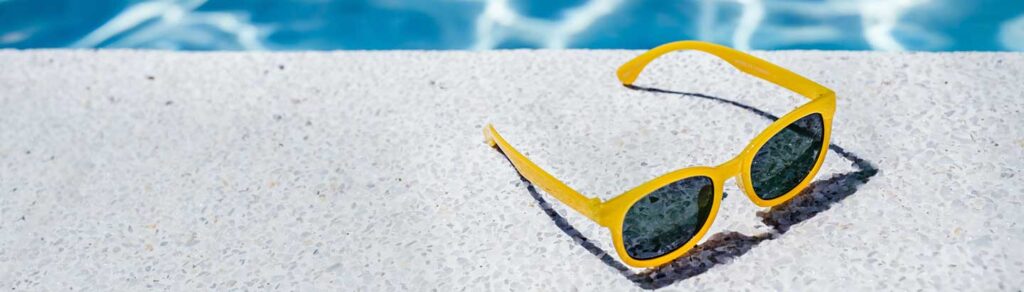 sunglasses next to a pool