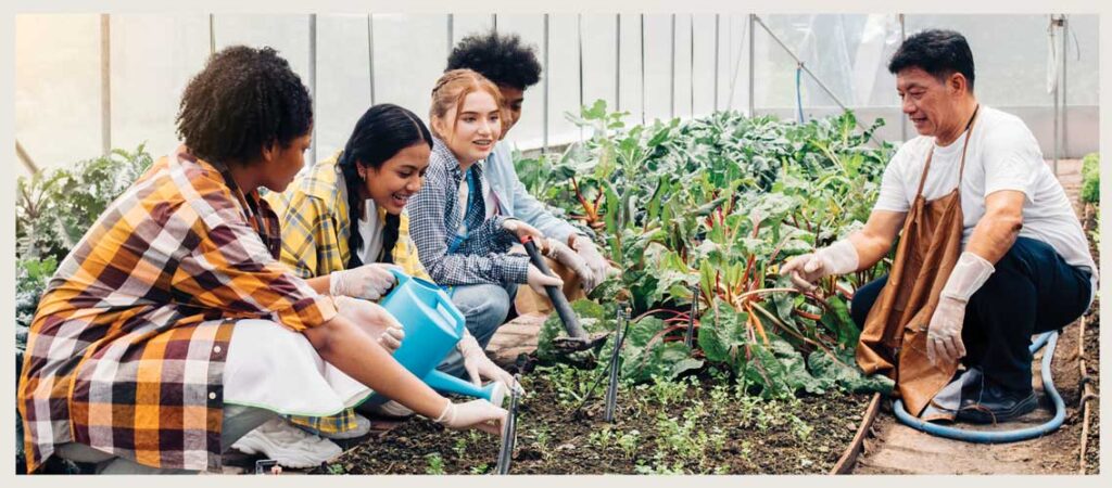 kids meet with an older community member in a greenhouse