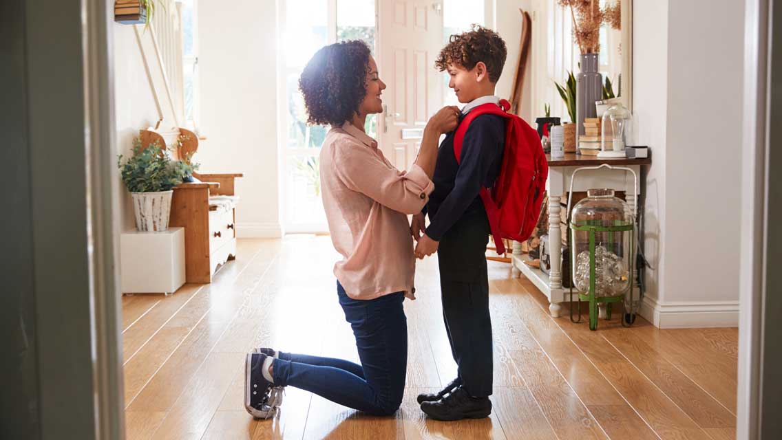 a mom prepares her son for the first day of school