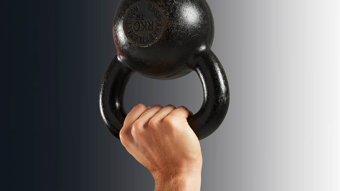 a hand holds a kettlebell