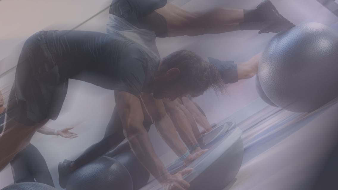 A blurry image of people working out on a bosu ball.