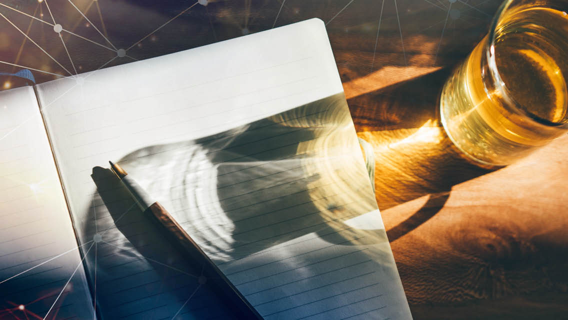 a amber colored beverage with a shadow on a journal