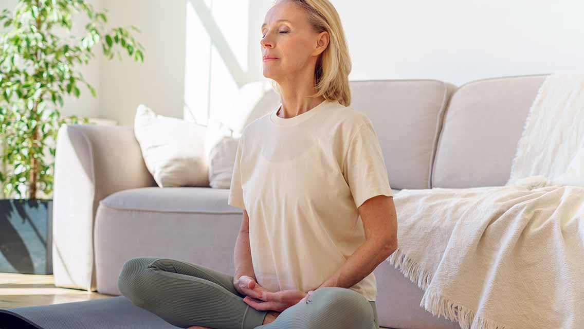 a woman sitting cross legged on the floor meditating