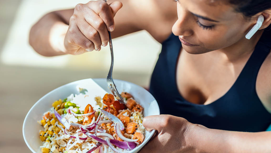 a woman eats a healthy bowl of food