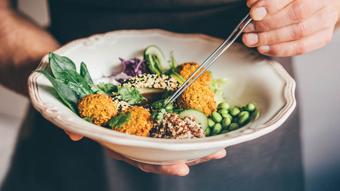 a person eats a plant-based bowl of food.