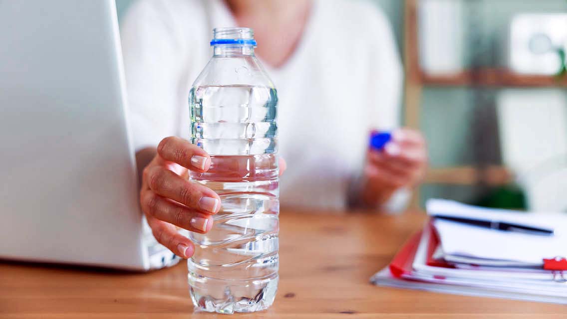 a person holds a bottle of water.