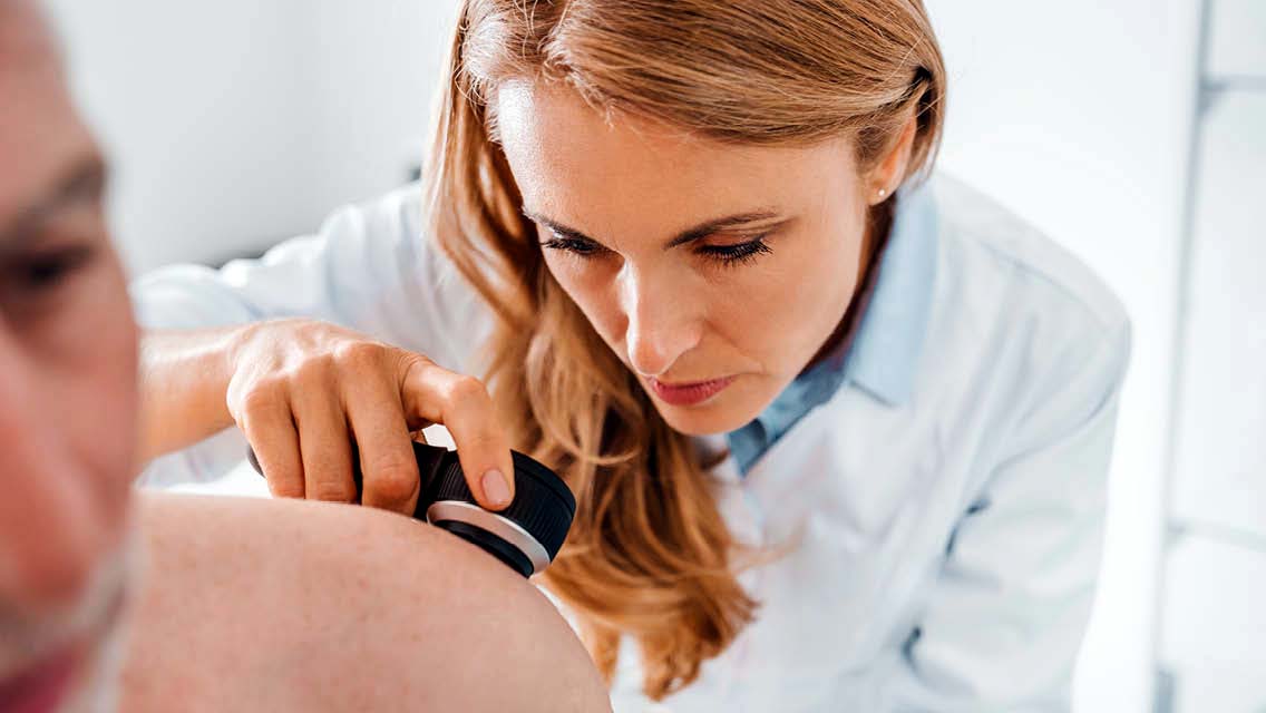 a doctor examines a patient's skin.