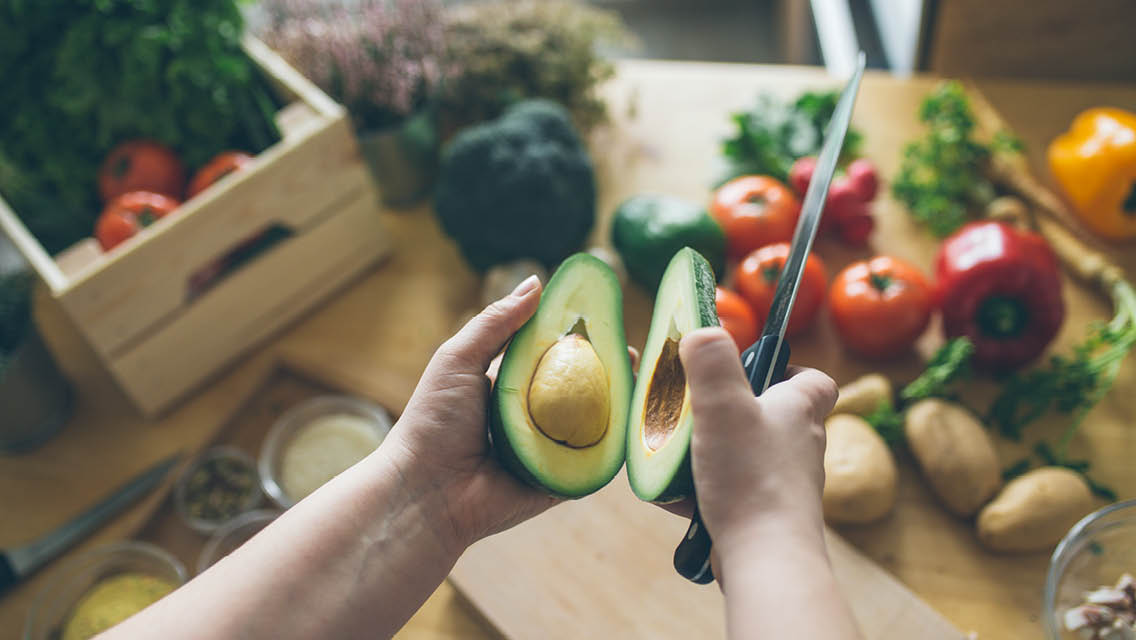 a person cuts open an avocado