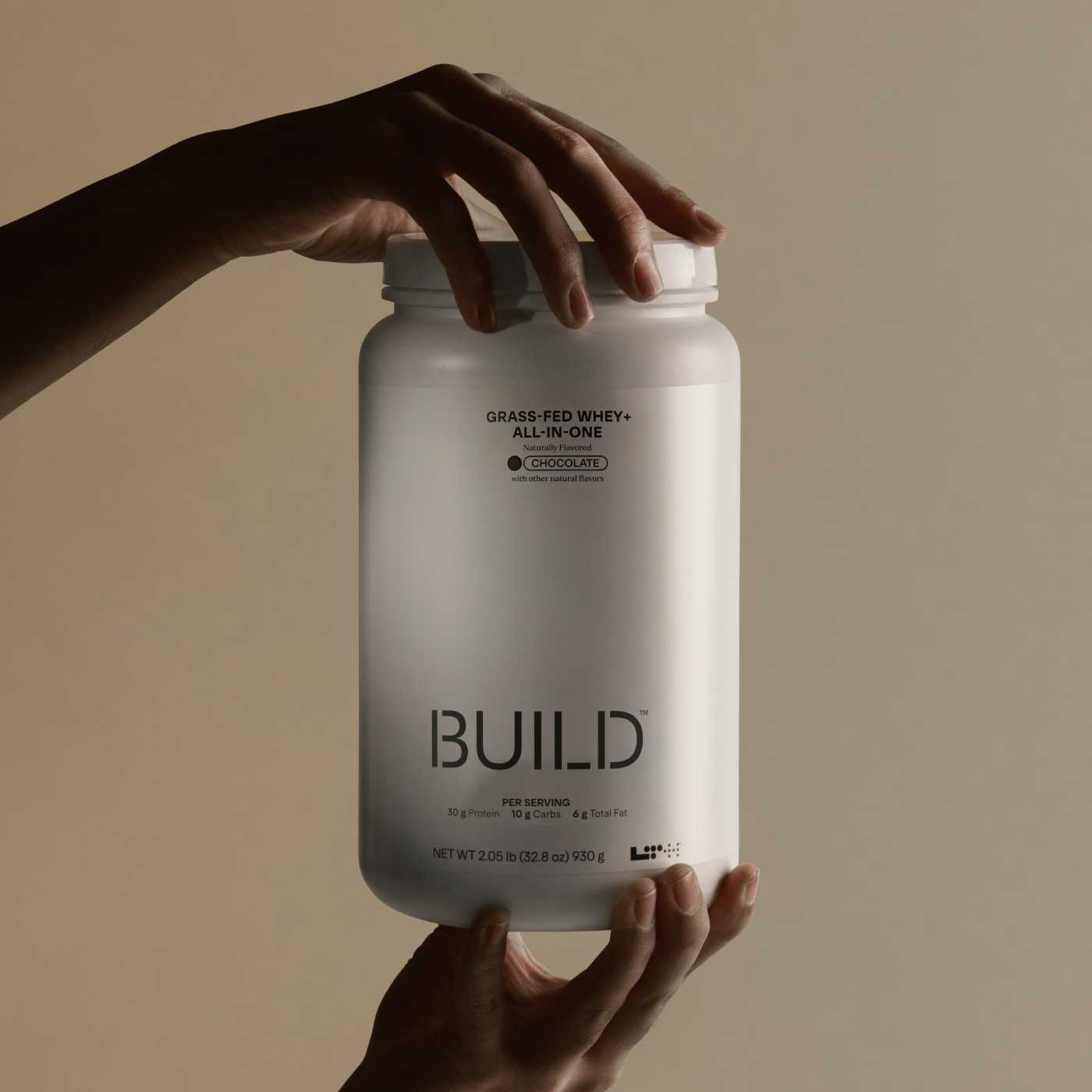 person holding a jug of all-in-one protein powder