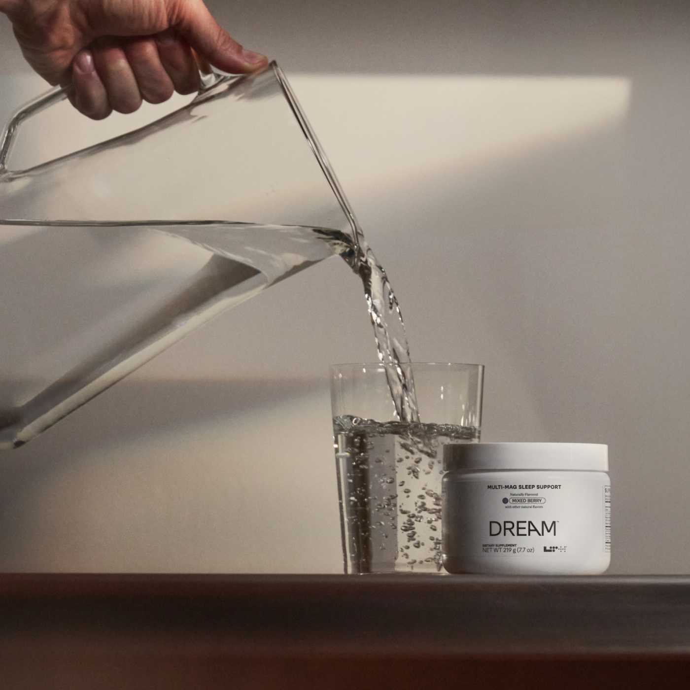 person pouring water in a pitch with LTH Dream next to it